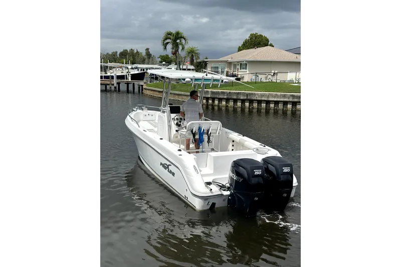 Slide: The Image of 2014 Pro-Line 26 Super Sport boat with dual Mercury engines on a calm waterway. - 5