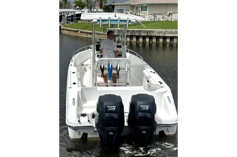 Slide: The Image of 2014 Pro-Line 26 Super Sport boat with dual outboard engines on a calm waterway. - 6