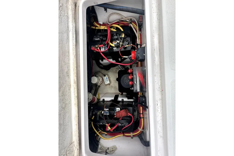 Slide: The Image of 2014 Pro-Line 26 Super Sport boat battery compartment with wiring and components. - 61