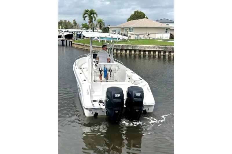Slide: The Image of 2014 Pro-Line 26 Super Sport boat with dual engines on a calm waterway. - 7