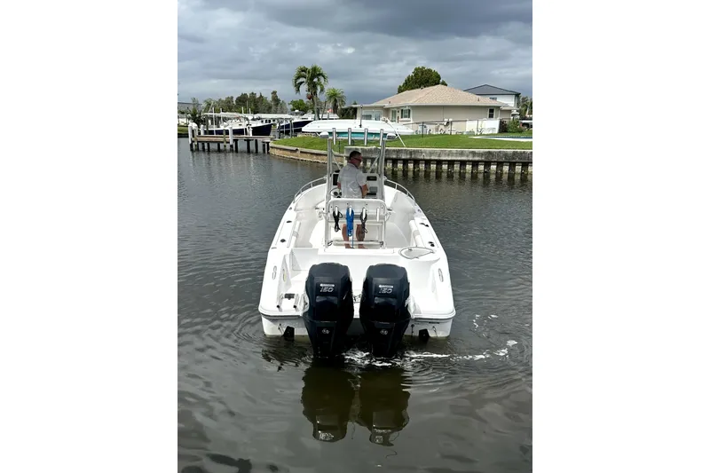 Slide: The Image of 2014 Pro-Line 26 Super Sport boat on a calm waterway, overcast sky. - 8