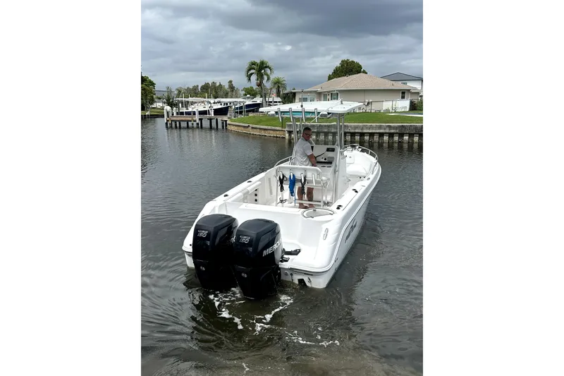 Slide: The Image of 2014 Pro-Line 26 Super Sport boat with dual Mercury engines on a calm waterway. - 9