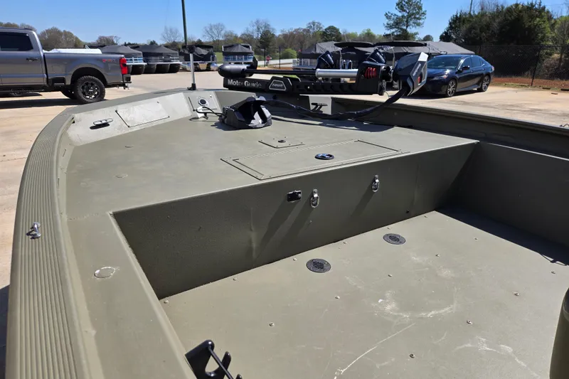 Slide: The Image of 2025 Tracker Grizzly 1860 CC boat with spacious deck and motor guide, parked outdoors. - 11