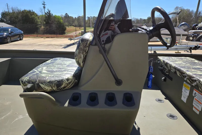 Slide: The Image of 2025 Tracker Grizzly 1860 CC boat interior with camo seats and steering console. - 14