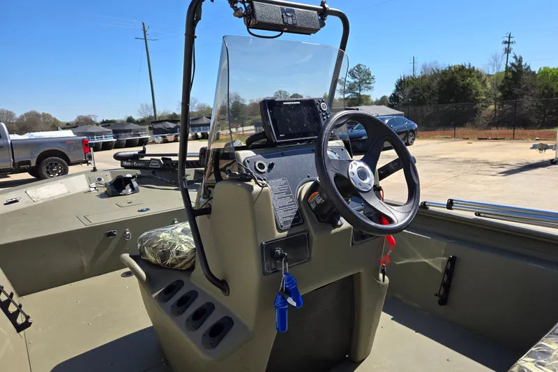 Slide: The Image of 2025 Tracker Grizzly 1860 CC boat interior with steering wheel and control panel. - 16