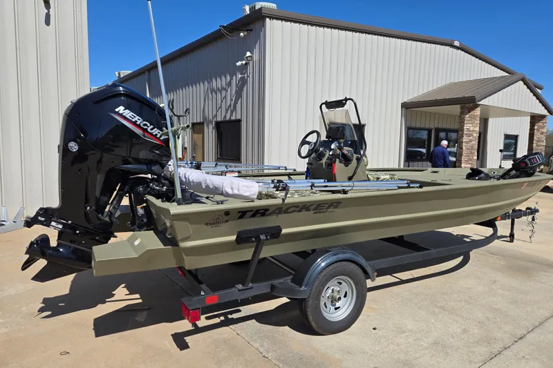 Slide: The Image of 2025 Tracker Grizzly 1860 CC boat with Mercury engine on trailer, parked outside a building. - 3
