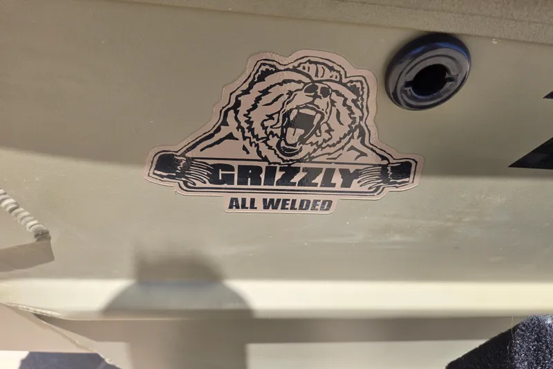 Slide: The Image of Sticker on 2025 Tracker Grizzly 1860 CC boat, featuring "Grizzly All Welded" logo. - 7