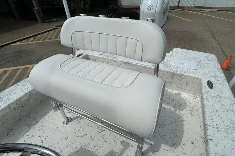 Slide: The Image of 2026 Coastal Skiff 231 Flats boat with white cushioned seating and sleek design. - 10