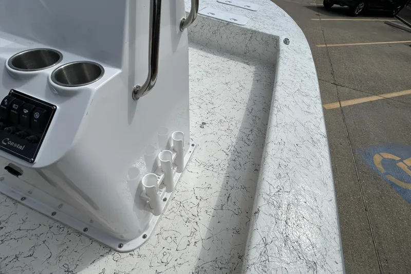 Slide: The Image of 2026 Coastal Skiff 231 Flats boat interior with cup holders and rod holders. - 13