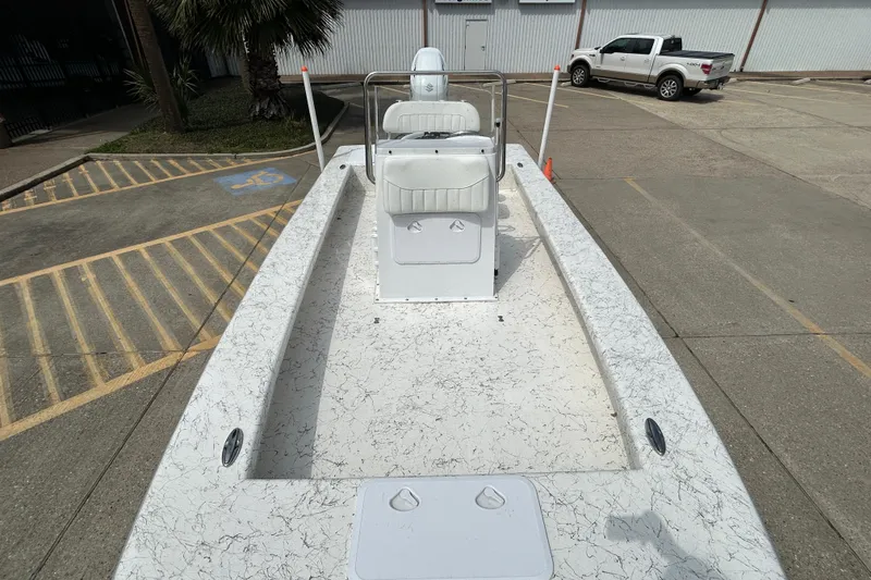 Slide: The Image of 2026 Coastal Skiff 231 Flats boat in a parking lot, showcasing its spacious deck design. - 15