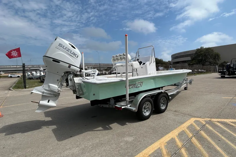 Slide: The Image of 2026 Coastal Skiff 231 Flats boat with Suzuki engine on a trailer in a parking lot. - 4