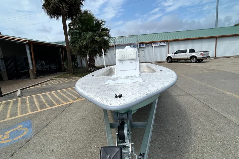 Slide: The Image of 2026 Coastal Skiff 231 Flats boat on trailer in parking lot, palm tree nearby. - 6