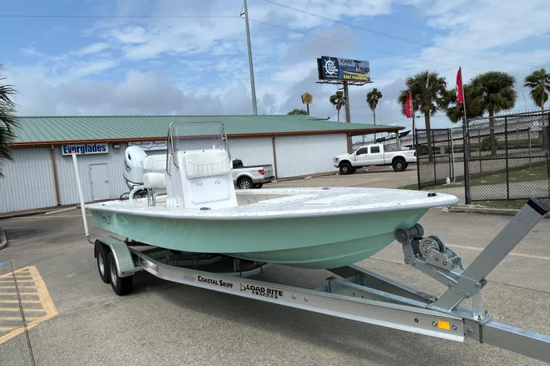 Slide: The Image of 2026 Coastal Skiff 231 Flats boat on trailer, parked outdoors near dealership. - 7