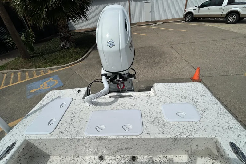 Slide: The Image of 2026 Coastal Skiff 231 Flats boat with Suzuki outboard motor in parking lot. - 8