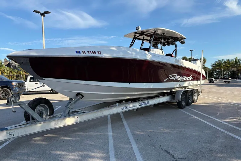 Slide: The Image of 2021 Renegade 33 boat on trailer in parking lot under clear sky. - 13