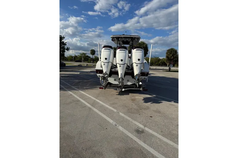 Slide: The Image of 2021 Renegade 33 boat with triple 350 horsepower engines in a parking lot. - 15