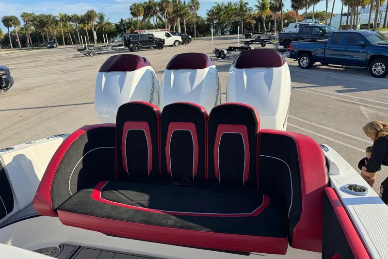 Slide: The Image of 2021 Renegade 33 boat with red and black seating, triple outboard engines. - 8
