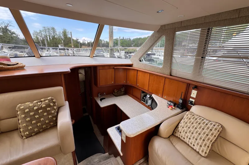 Slide: The Image of Interior of 2004 Silverton 38 Convertible yacht with plush seating and wooden cabinetry. - 11