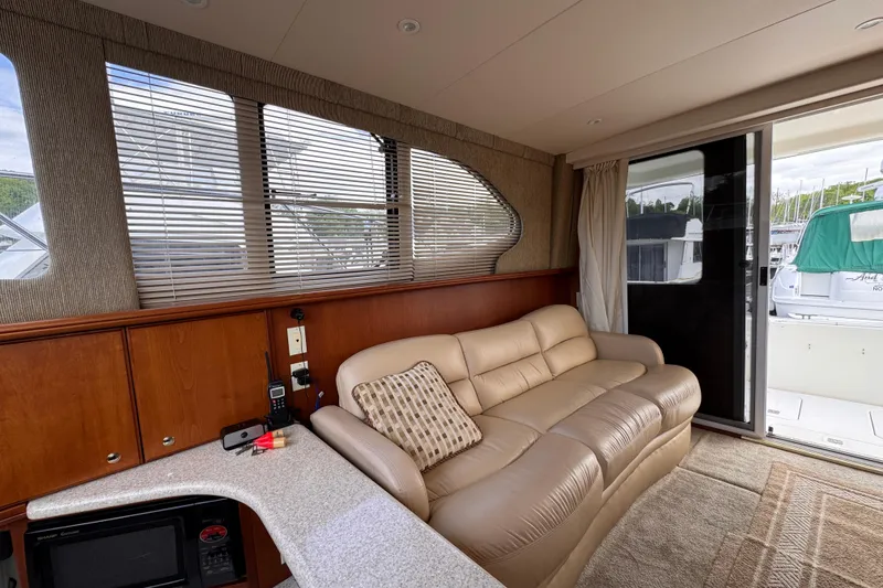Slide: The Image of Interior of 2004 Silverton 38 Convertible yacht with beige leather sofa and wooden cabinetry. - 12