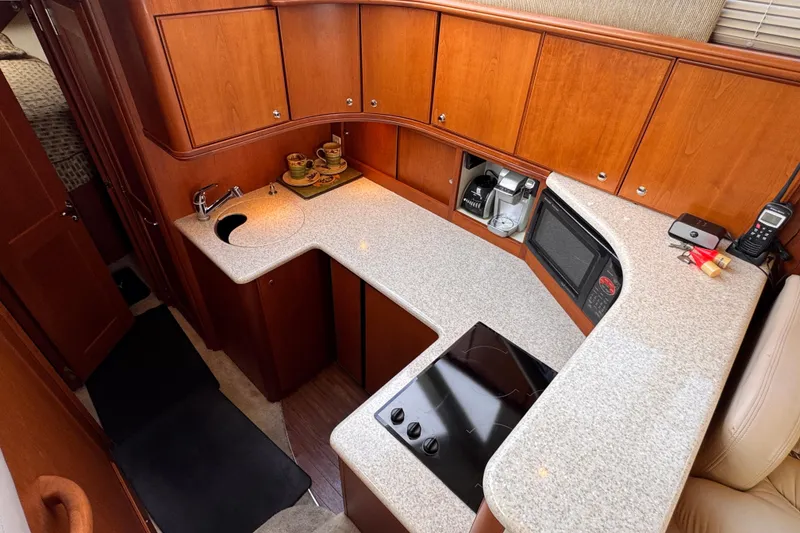 Slide: The Image of 2004 Silverton 38 Convertible yacht kitchen with wooden cabinets and modern appliances. - 15