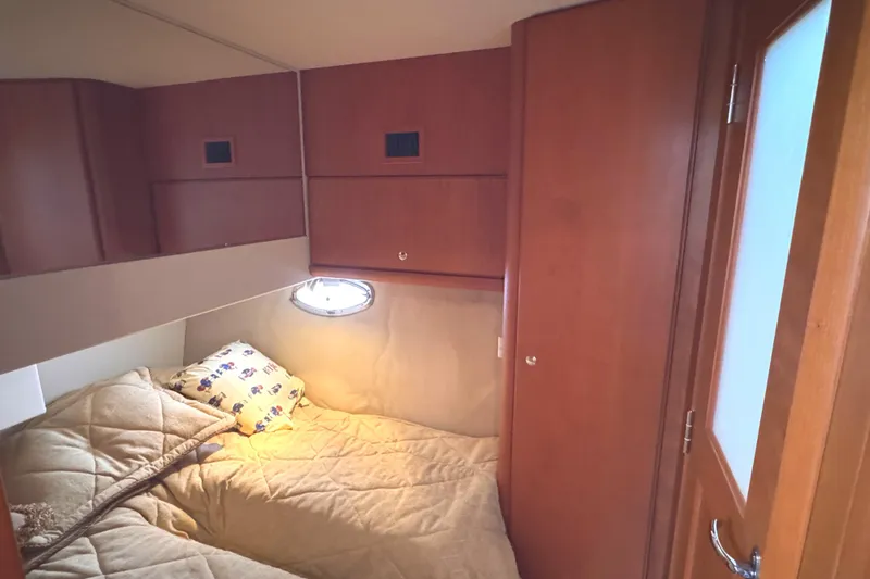 Slide: The Image of Cozy cabin interior of 2004 Silverton 38 Convertible yacht with wood paneling and bedding. - 19