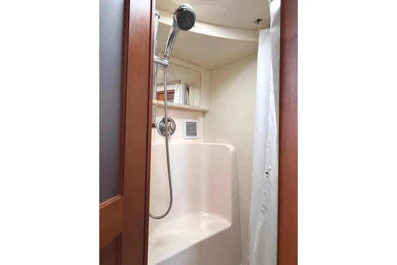 Slide: The Image of Shower area in 2004 Silverton 38 Convertible yacht, featuring a handheld showerhead and curtain. - 20