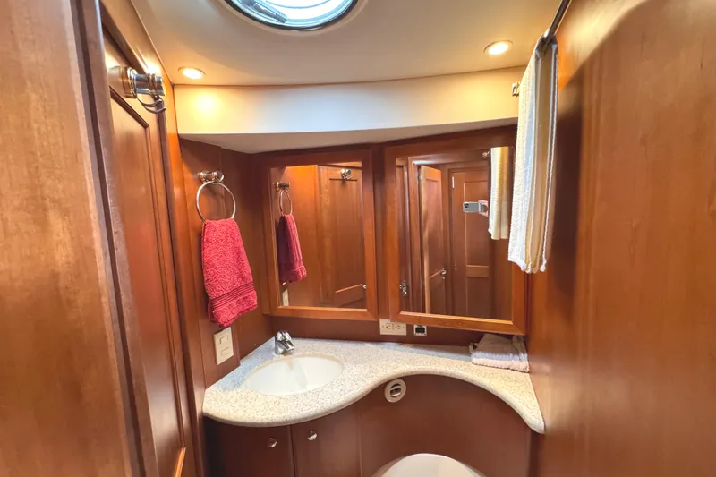 Slide: The Image of Luxurious 2004 Silverton 38 Convertible yacht bathroom with wood cabinetry and modern fixtures. - 22
