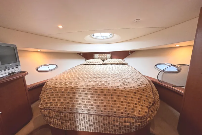 Slide: The Image of Luxurious cabin interior of 2004 Silverton 38 Convertible yacht with cozy bedding and portholes. - 23