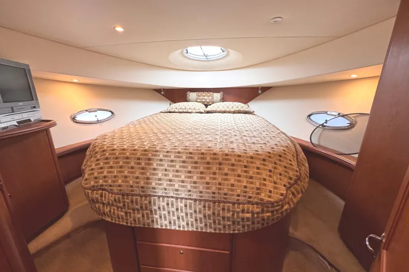 Slide: The Image of Luxurious cabin interior of 2004 Silverton 38 Convertible yacht with cozy bed and portholes. - 24