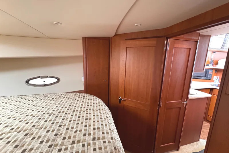 Slide: The Image of 2004 Silverton 38 Convertible yacht interior with wood paneling and cozy bedroom. - 25