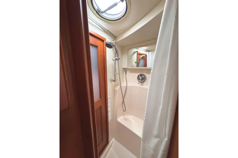 Slide: The Image of Shower area in 2004 Silverton 38 Convertible yacht with wooden door and porthole window. - 27