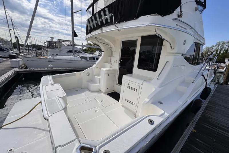 Slide: The Image of 2004 Silverton 38 Convertible yacht docked, showcasing spacious deck and sleek design. - 28
