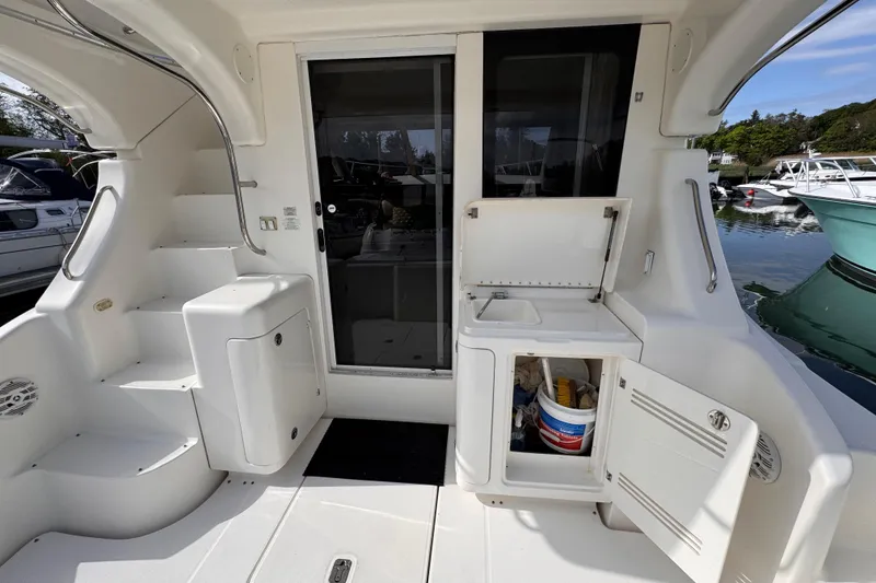 Slide: The Image of 2004 Silverton 38 Convertible yacht cockpit with storage and sink, docked at marina. - 31