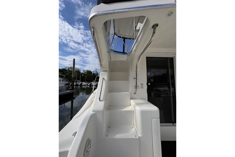 Slide: The Image of 2004 Silverton 38 Convertible yacht with stairs and marina view under blue sky. - 32