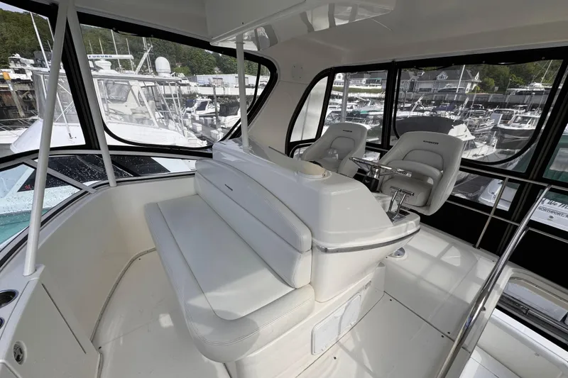 Slide: The Image of 2004 Silverton 38 Convertible yacht interior with helm seats and marina view. - 35