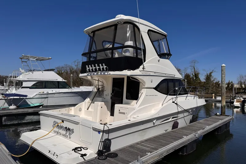 Slide: The Image of 2004 Silverton 38 Convertible yacht docked at marina under clear blue sky. - 5