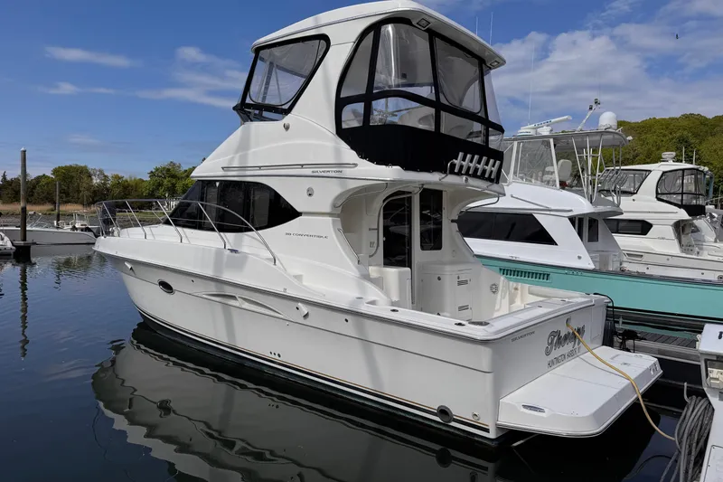 Slide: The Image of 2004 Silverton 38 Convertible yacht docked at marina under clear blue sky. - 6