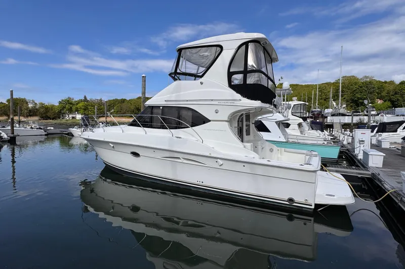 Slide: The Image of 2004 Silverton 38 Convertible yacht docked at marina under blue sky. - 7