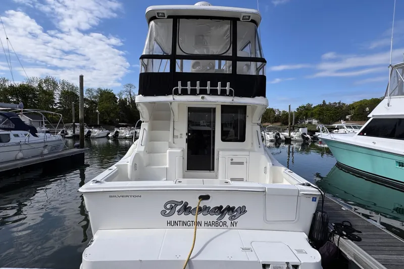 Slide: The Image of 2004 Silverton 38 Convertible yacht docked at Huntington Harbor, NY, under a clear sky. - 8