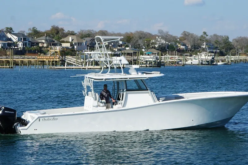 Slide: The Image of 2025 Onslow Bay 41 Tournament boat cruising on a scenic waterfront. - 11