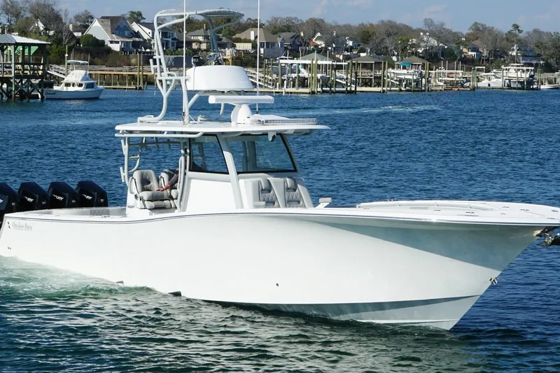 Slide: The Image of 2025 Onslow Bay 41 Tournament boat cruising in a marina with waterfront homes. - 4