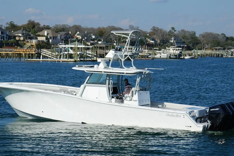 Slide: The Image of 2025 Onslow Bay 41 Tournament boat cruising on a scenic waterfront. - 6