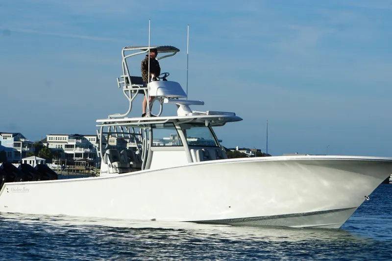 Slide: The Image of 2025 Onslow Bay 41 Tournament boat cruising near coastal homes. - 7