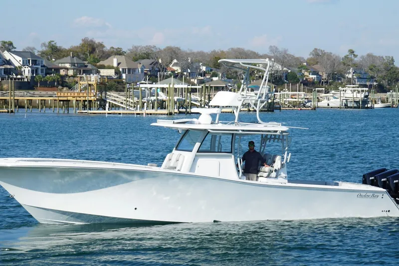 Slide: The Image of 2025 Onslow Bay 41 Tournament boat cruising near waterfront homes. - 8