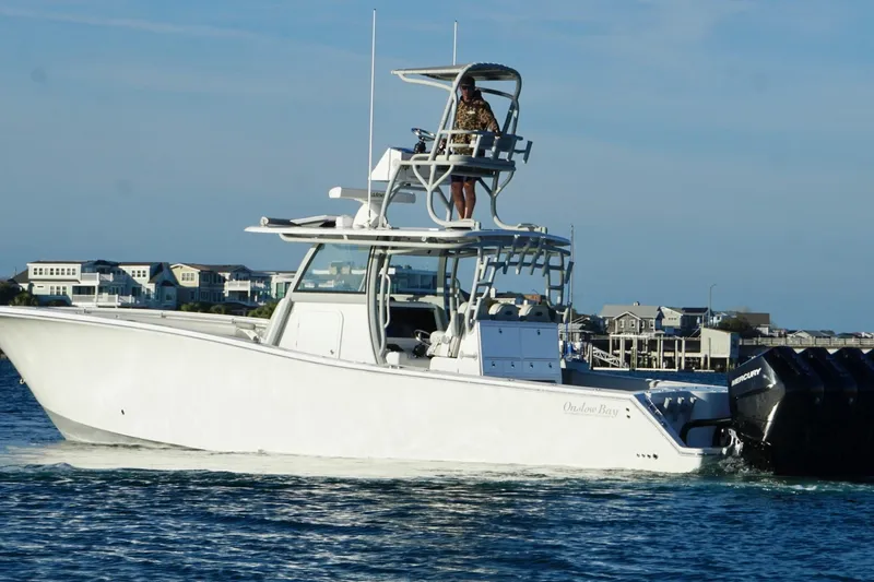 Slide: The Image of 2025 Onslow Bay 41 Tournament boat cruising on water near coastal homes. - 9