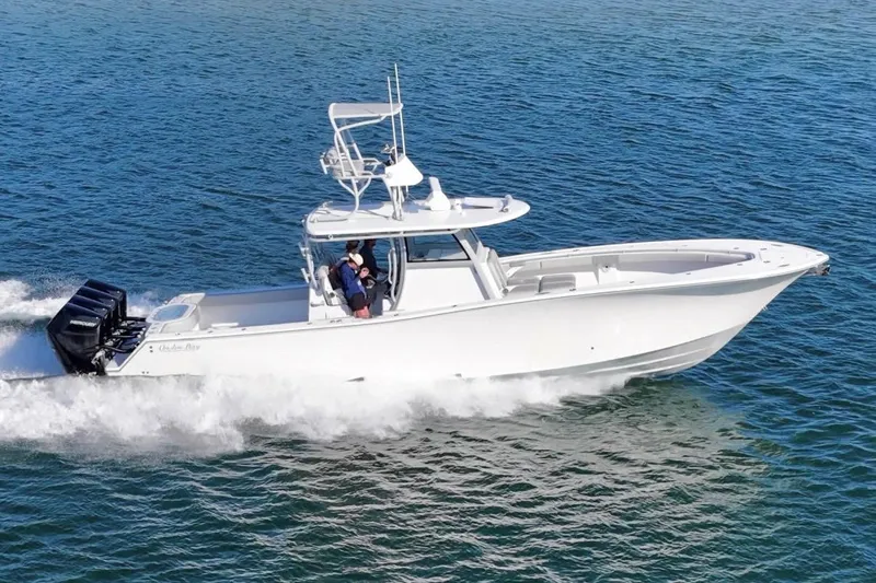 Slide: The Image of 2025 Onslow Bay 41 Tournament boat cruising on a sunny day near a coastal town. - 3