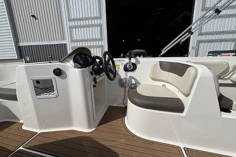 Slide: The Image of 2018 Bayliner Element E21 boat interior with steering wheel and seating. - 10