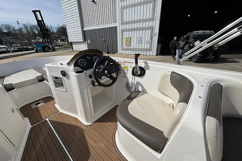Slide: The Image of 2018 Bayliner Element E21 boat interior with steering wheel and seating area. - 11