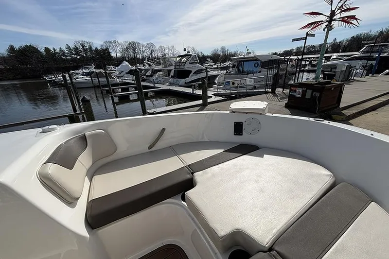 Slide: The Image of 2018 Bayliner Element E21 boat interior with comfortable seating at a marina dock. - 20