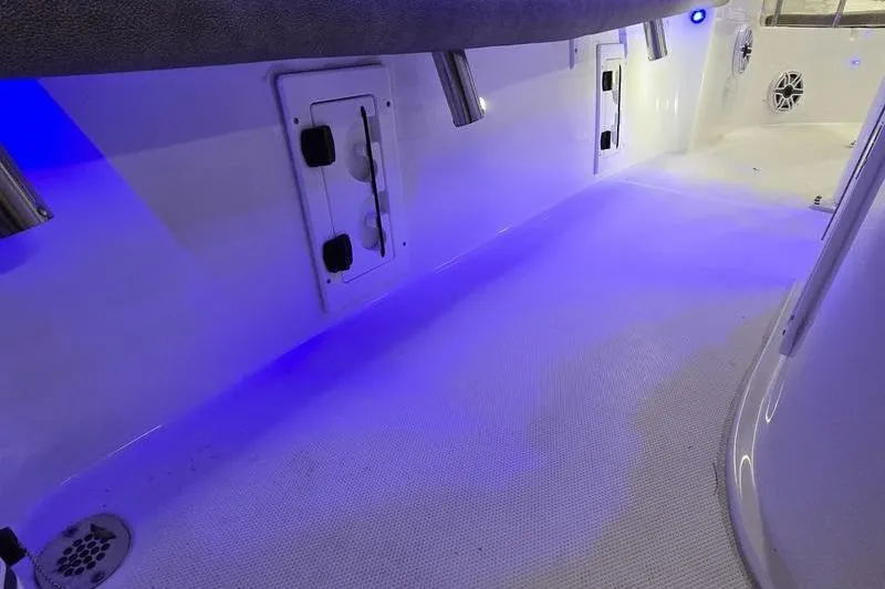 Slide: The Image of 2025 Sea Hunt BX 25 FS boat interior with blue LED lighting and storage compartments. - 12